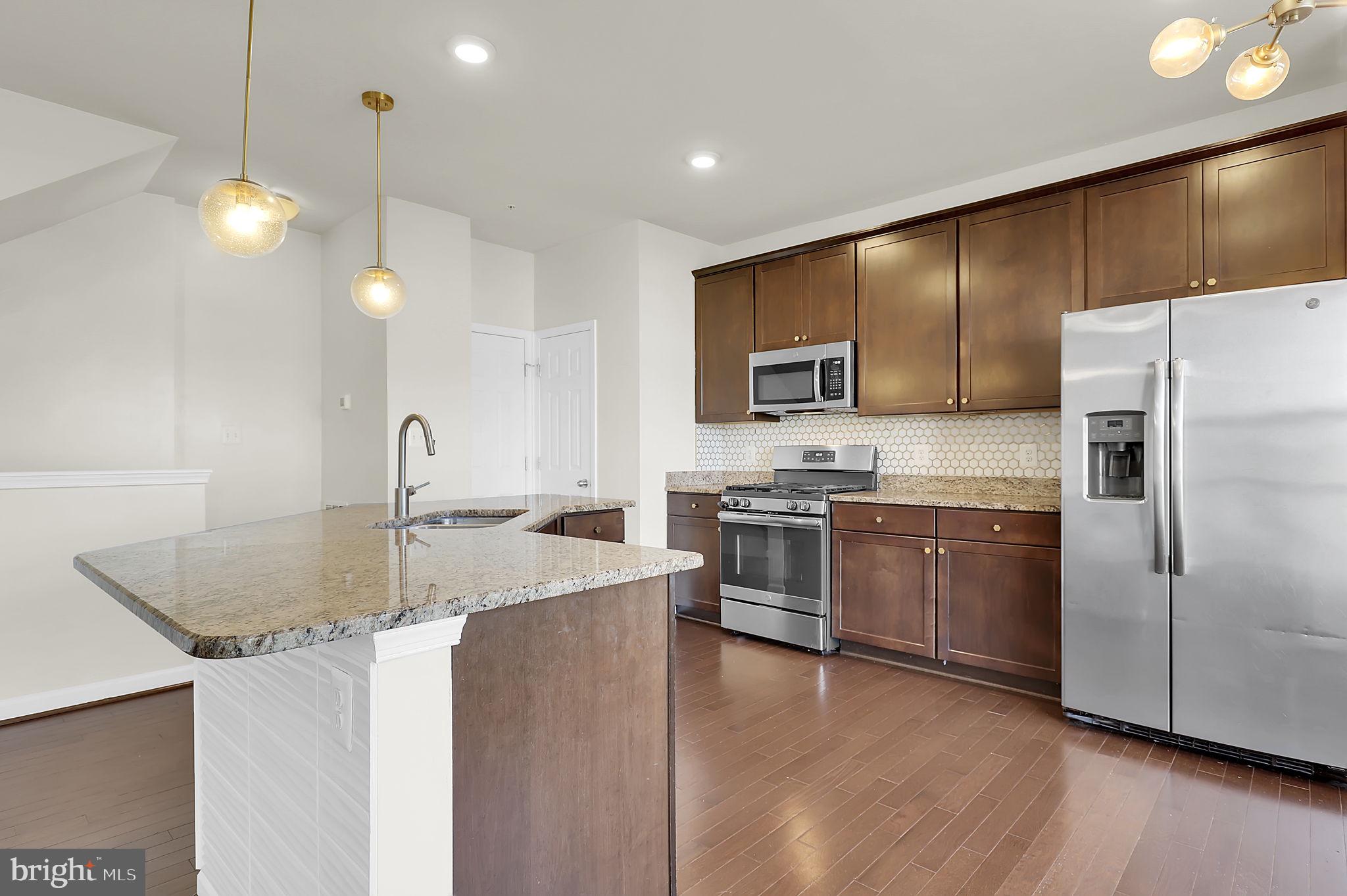5906 Krantz Drive Frederick, MD 21703 - Photo 8 of 40 a kitchen with stainless steel appliances granite countertop a sink a stove and a refrigerator