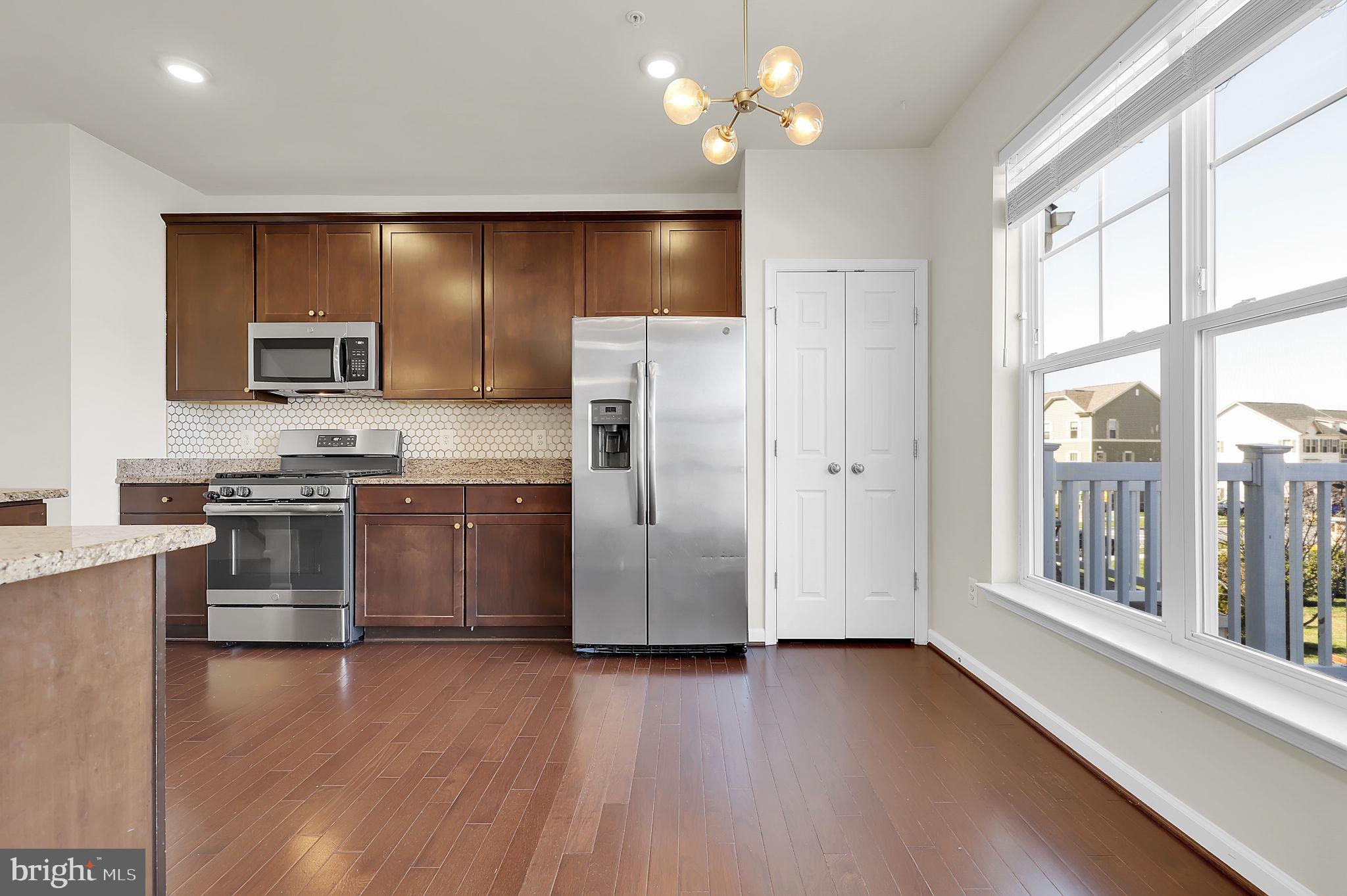 5906 Krantz Drive Frederick, MD 21703 - Photo 9 of 40 a kitchen with stainless steel appliances a refrigerator a stove a sink and a large window