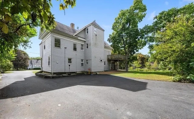 a view of a house with backyard and trees