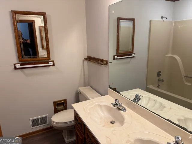 a bathroom with a sink toilet and mirror