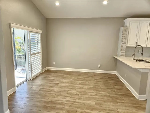 a view of a kitchen with wooden floor and a sink