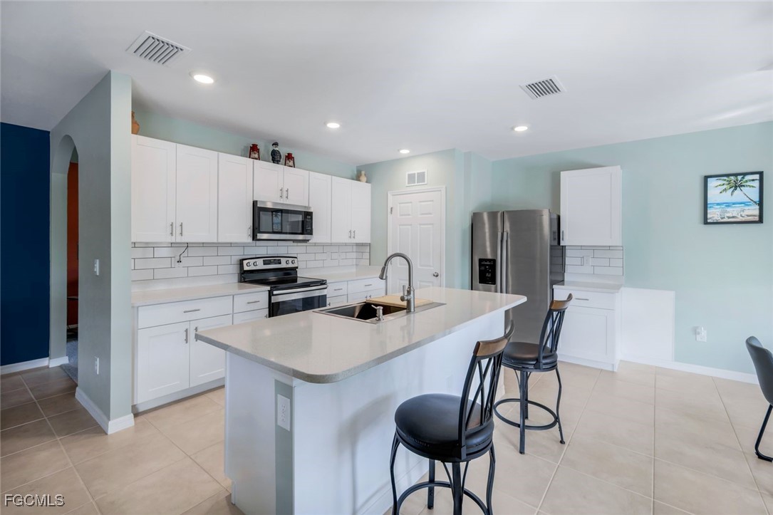 566 Corrientes Circle Punta Gorda, FL 33983 - Photo 14 of 36 a kitchen with white cabinets and stainless steel appliances