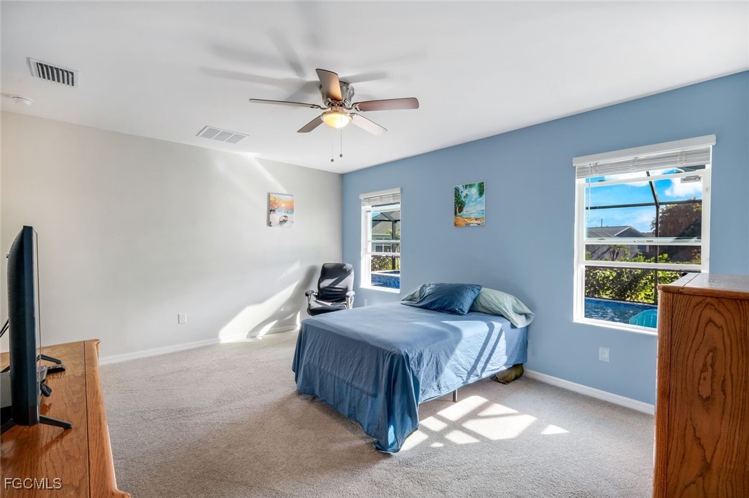 566 Corrientes Circle Punta Gorda, FL 33983 - Photo 19 of 36 a bedroom with a bed and a chandelier