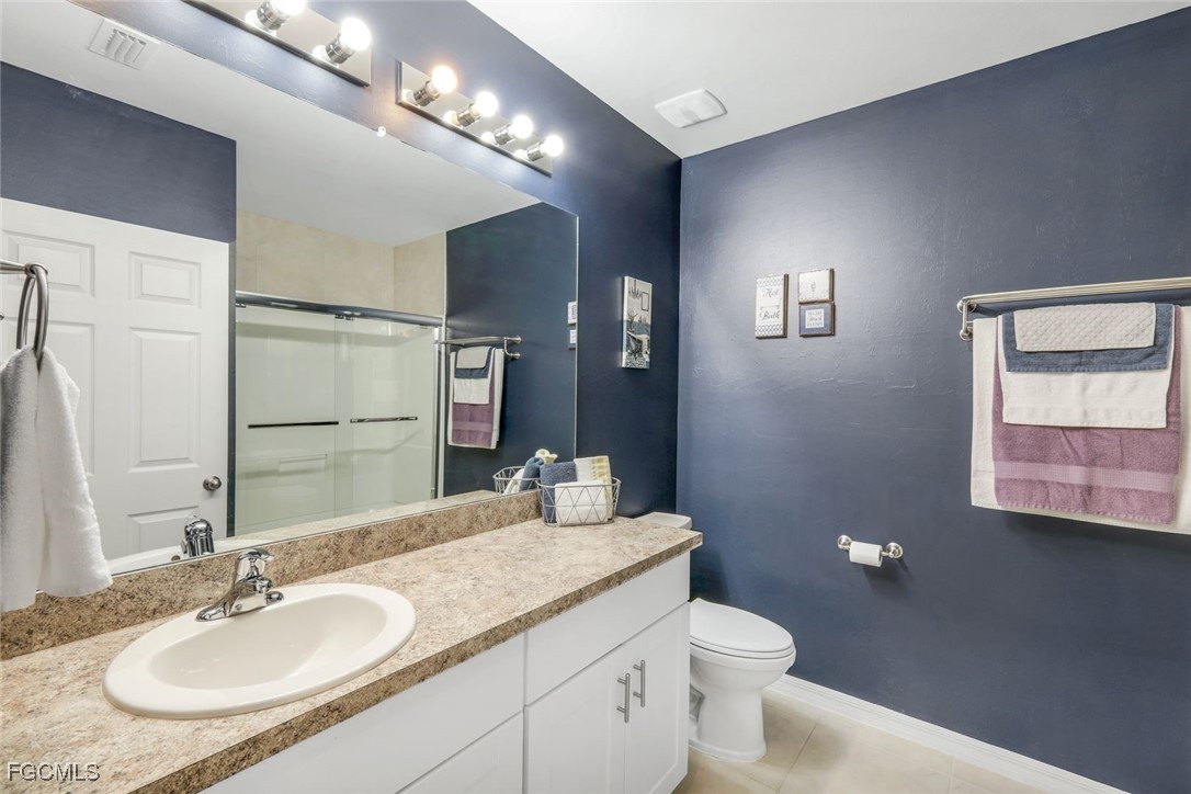 566 Corrientes Circle Punta Gorda, FL 33983 - Photo 23 of 36 a bathroom with a granite countertop sink a toilet and a mirror