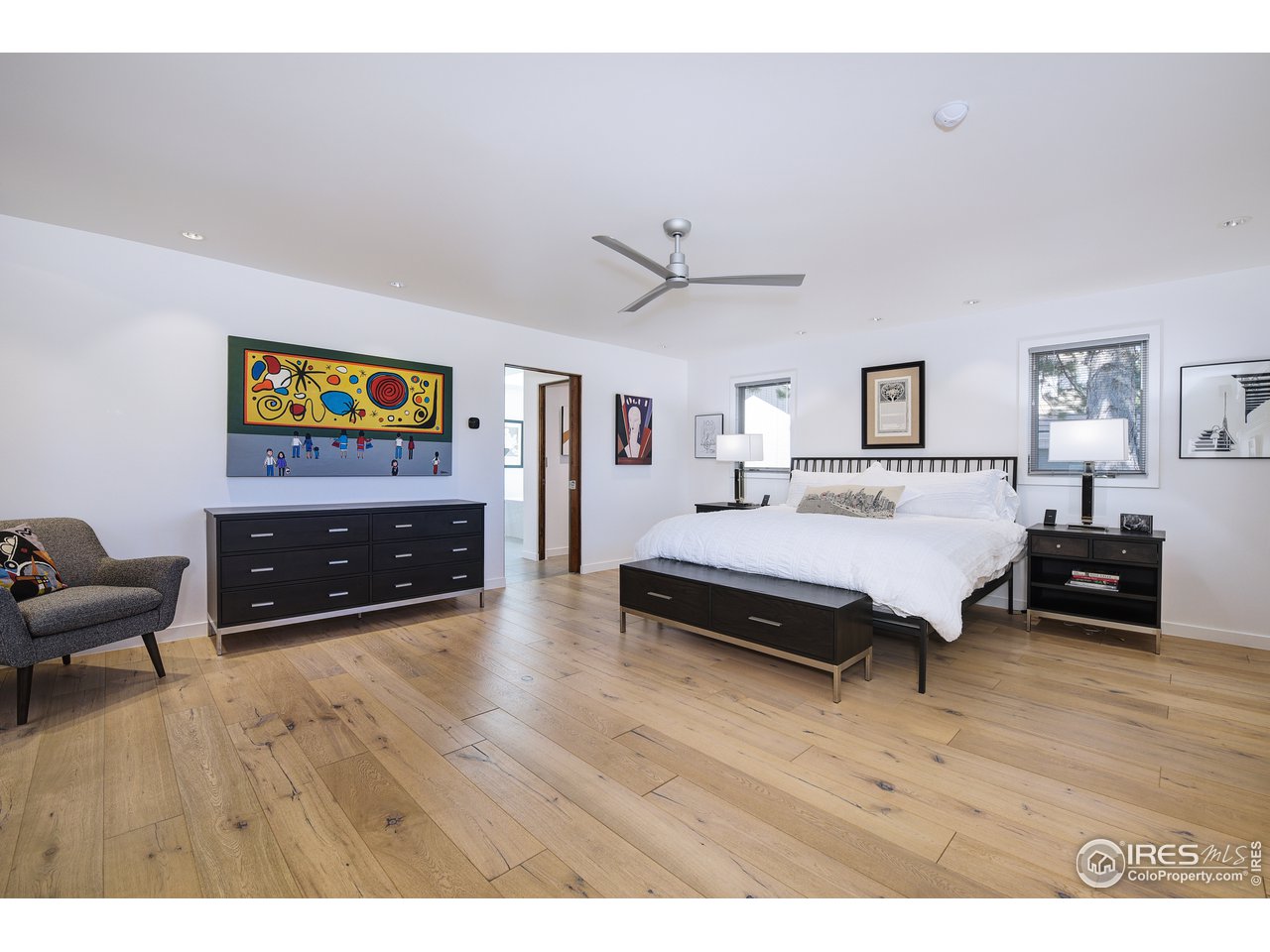 7006 Roaring Fork Trail Boulder, CO 80301 - Photo 22 of 40 a spacious bedroom with a bed a couch and a bookshelf