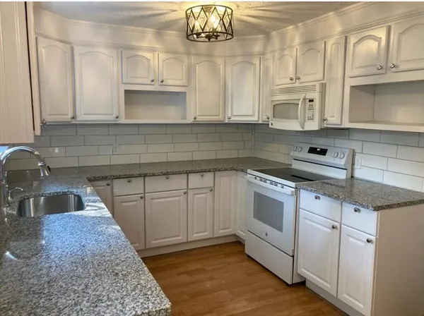 a kitchen with granite countertop a sink stainless steel appliances and cabinets