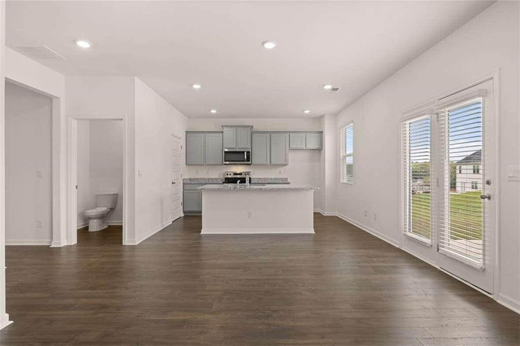 186 Aster Avenue Locust Grove, GA 30248 - Photo 11 of 46 a view of kitchen with kitchen island a sink wooden floor and stainless steel appliances