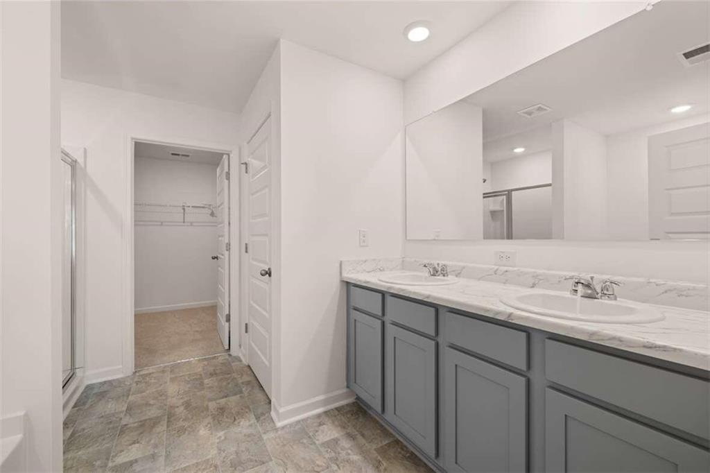 186 Aster Avenue Locust Grove, GA 30248 - Photo 16 of 46 a bathroom with a double vanity sink and a mirror
