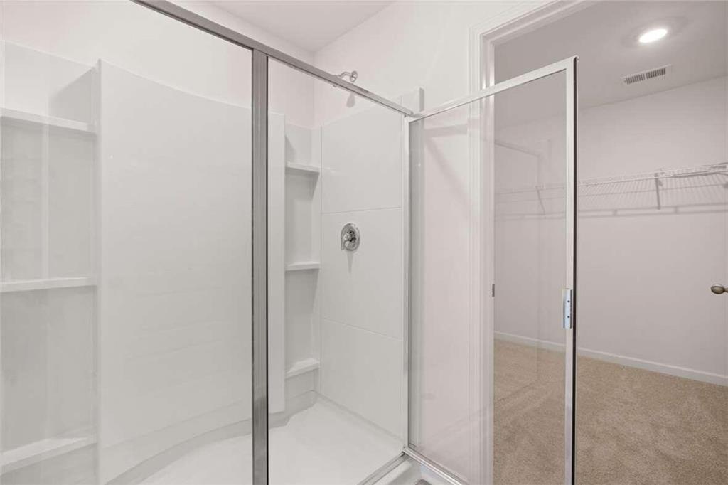186 Aster Avenue Locust Grove, GA 30248 - Photo 18 of 46 a bathroom with a glass shower door