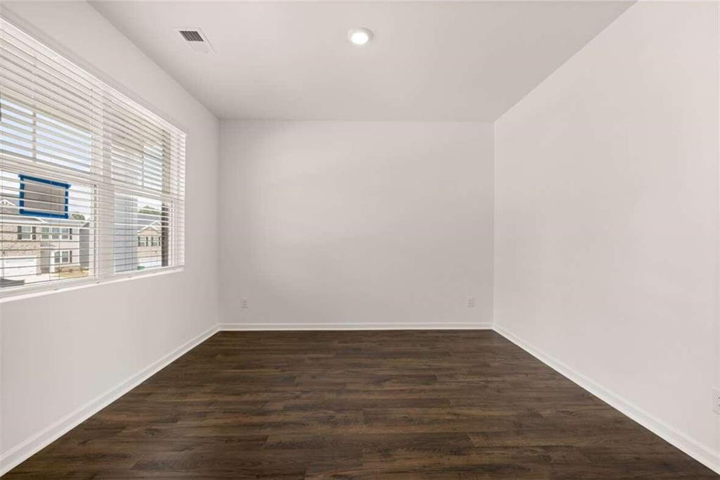 186 Aster Avenue Locust Grove, GA 30248 - Photo 20 of 46 a view of an empty room with wooden floor and a window
