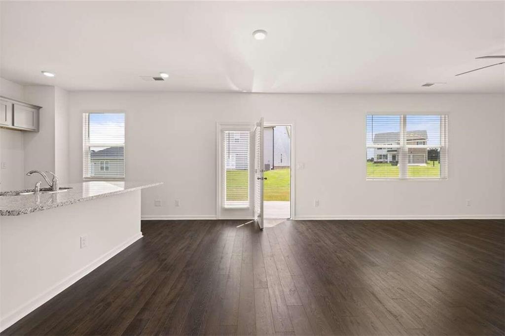 186 Aster Avenue Locust Grove, GA 30248 - Photo 23 of 46 a view of an empty room with a window and wooden floor