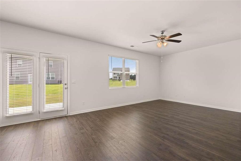 186 Aster Avenue Locust Grove, GA 30248 - Photo 27 of 46 a view of an empty room with a window and wooden floor