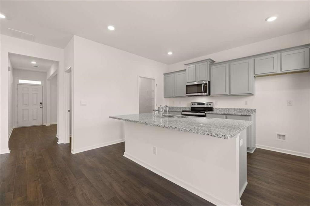186 Aster Avenue Locust Grove, GA 30248 - Photo 28 of 46 a kitchen with granite countertop a refrigerator stove top oven and sink