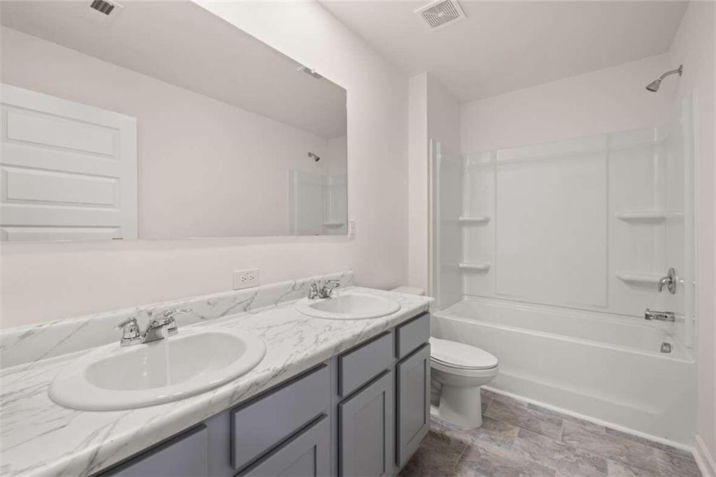 186 Aster Avenue Locust Grove, GA 30248 - Photo 35 of 46 a bathroom with a granite countertop sink a toilet and bathtub