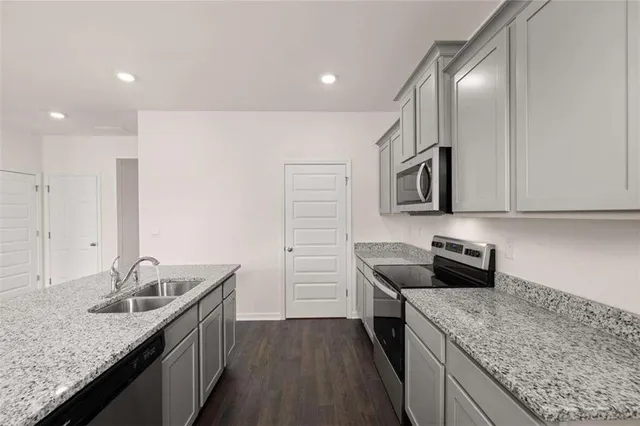 a view of kitchen with kitchen island a sink wooden floor and stainless steel appliances