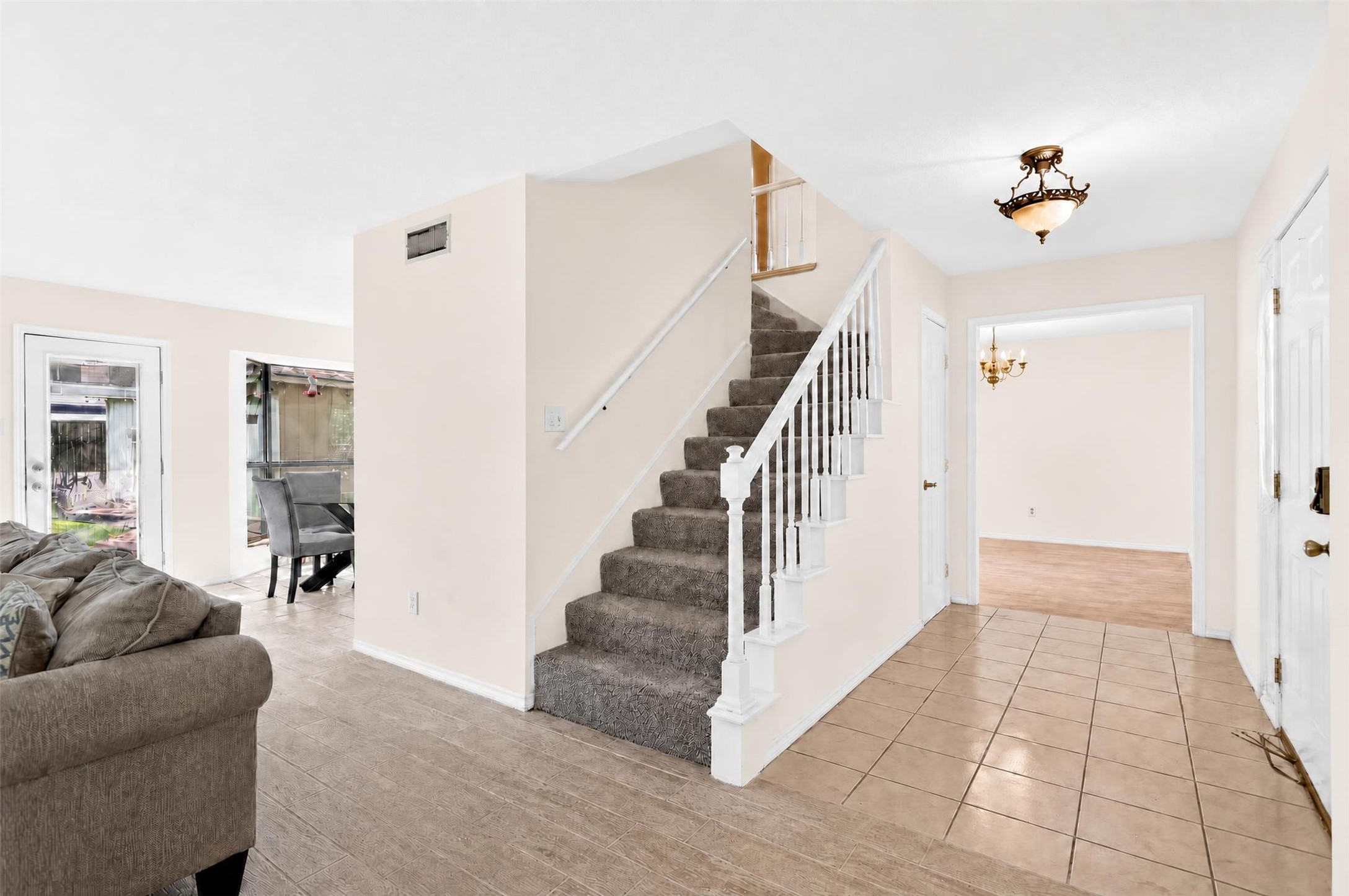 7019 Wyoma Trail Spring, TX 77379 - Photo 6 of 34 Bright and inviting entryway features a carpeted staircase, elegant chandelier, and access to multiple rooms with natural light streaming in from large windows.