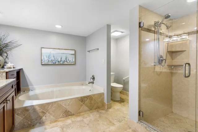 a spacious bathroom with a tub shower and a mirror