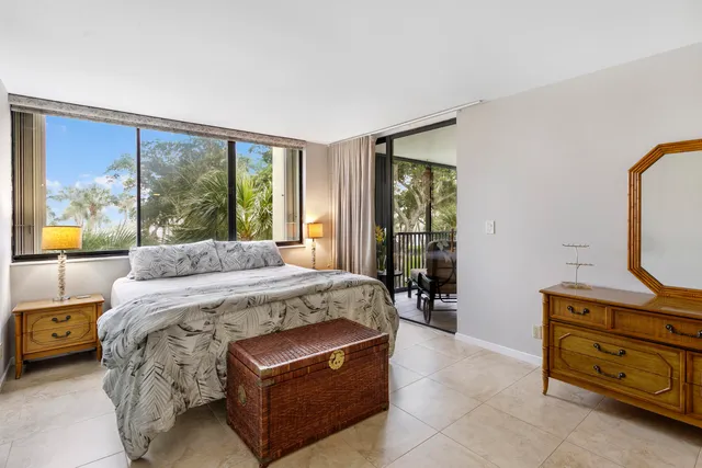 a bed sitting in a spacious bedroom next to a window