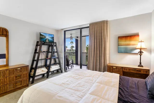 a bedroom with a bed and a flat tv screen on the dresser
