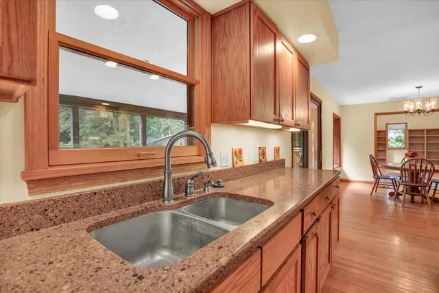 a kitchen with granite countertop wooden cabinets stainless steel appliances and a sink