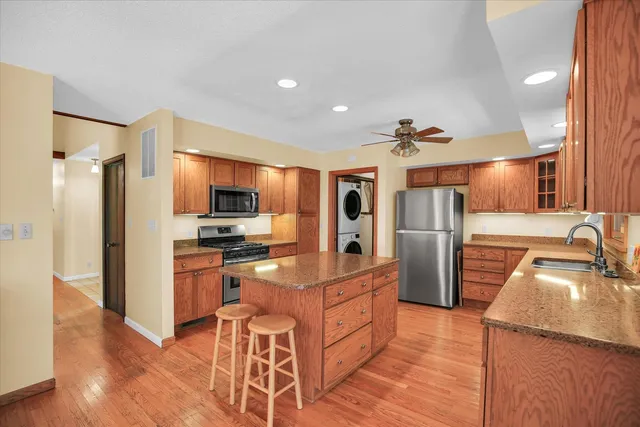 a kitchen with stainless steel appliances granite countertop a sink stove and refrigerator