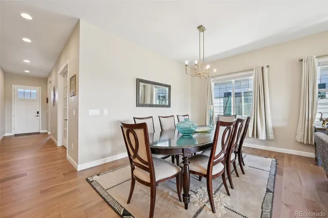 a kitchen with stainless steel appliances a dining table chairs and white cabinets