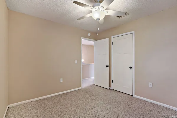an empty room with a ceiling fan and a fan