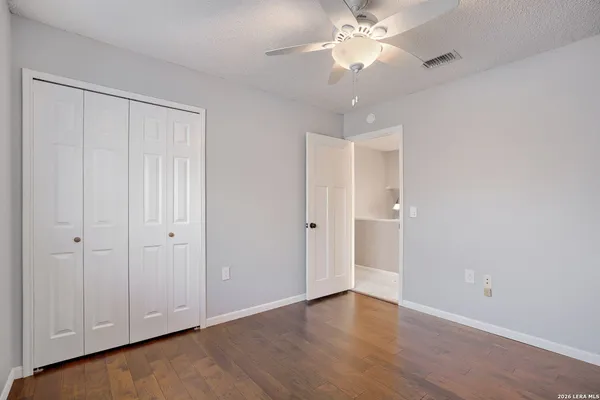 a view of an empty room and chandelier fan