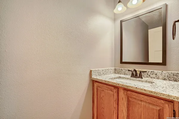 a bathroom with a granite countertop sink and a mirror