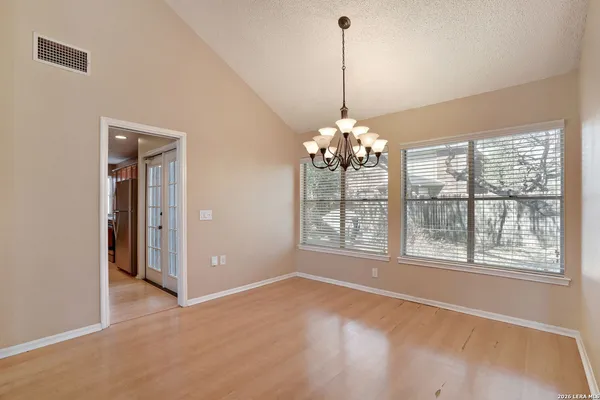 a view of an empty room with chandelier and a window
