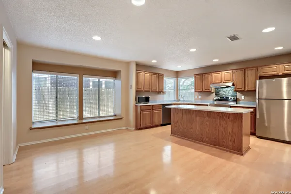 a kitchen with a refrigerator a sink and cabinets