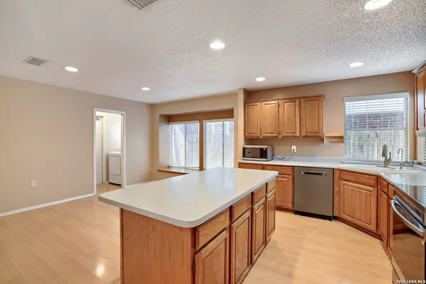 a kitchen with granite countertop a sink and white cabinets