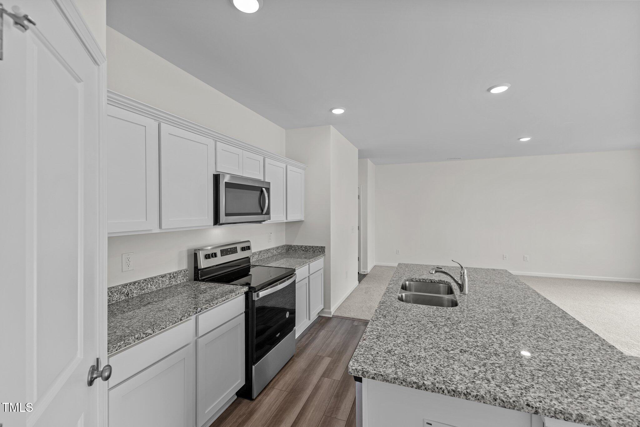 915 Dassault Ln Spring Spring Hope, NC 27882 - Photo 22 of 26 a kitchen with granite countertop stainless steel appliances a sink a stove top oven a counter space and cabinets