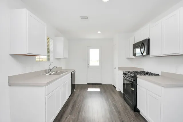 a kitchen with a sink stove and cabinets