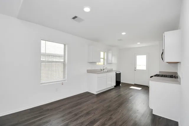 a kitchen with a wooden floor and a stove top oven