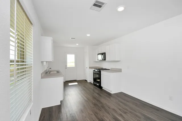 a kitchen with a wooden floor and a sink