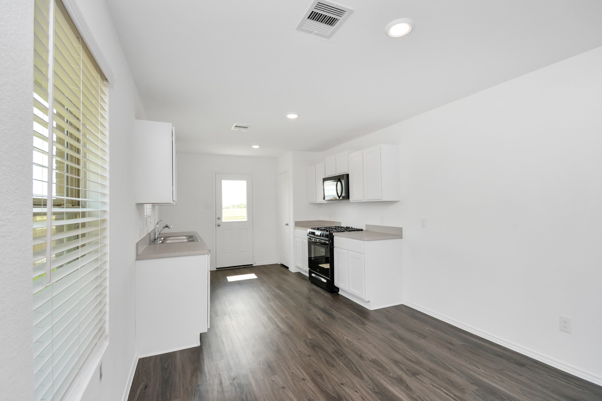 5035 Caledonia Lake Lane Rosharon, TX 77583 - Photo 28 of 37 a kitchen with a wooden floor and a sink