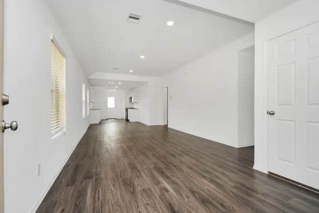 a view of empty room with wooden floor