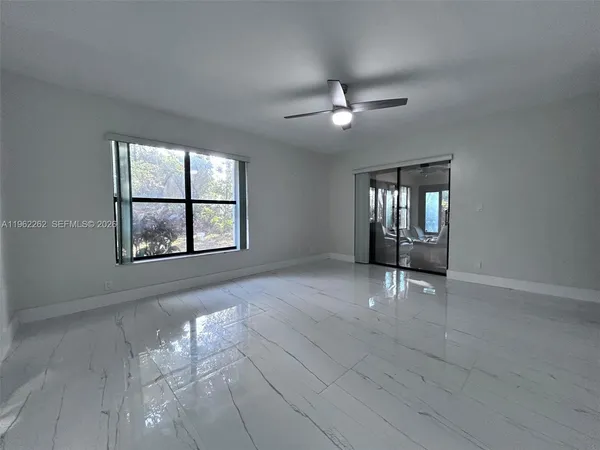 an empty room with windows and ceiling fan view