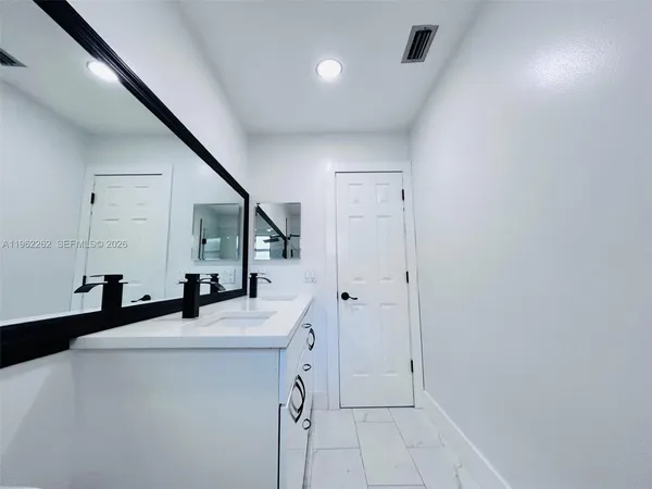 a view of a kitchen with a sink and a refrigerator