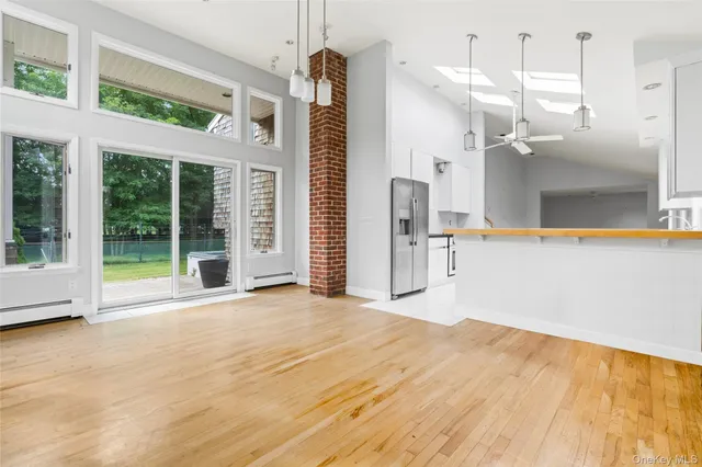 a kitchen with stainless steel appliances granite countertop a stove a sink a refrigerator and white cabinets