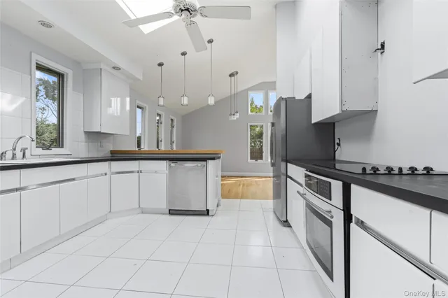 a kitchen with stainless steel appliances granite countertop a sink a stove and a refrigerator