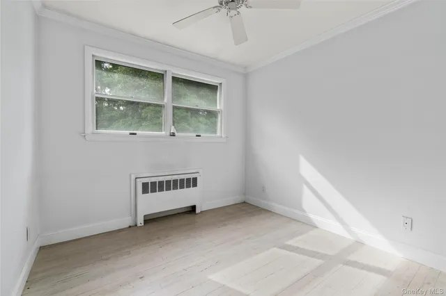 a view of an empty room with a window and a workspace