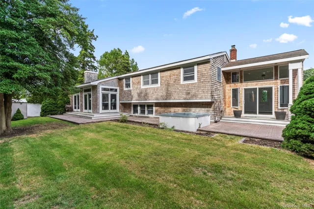 a view of house with a yard and potted plants