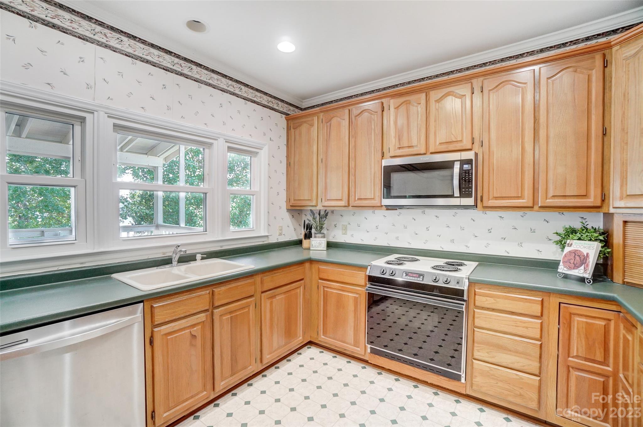 29025 Beaver Run Tega Cay, SC 29708 - Photo 14 of 42 a kitchen with stainless steel appliances wooden cabinets a stove a sink and a microwave
