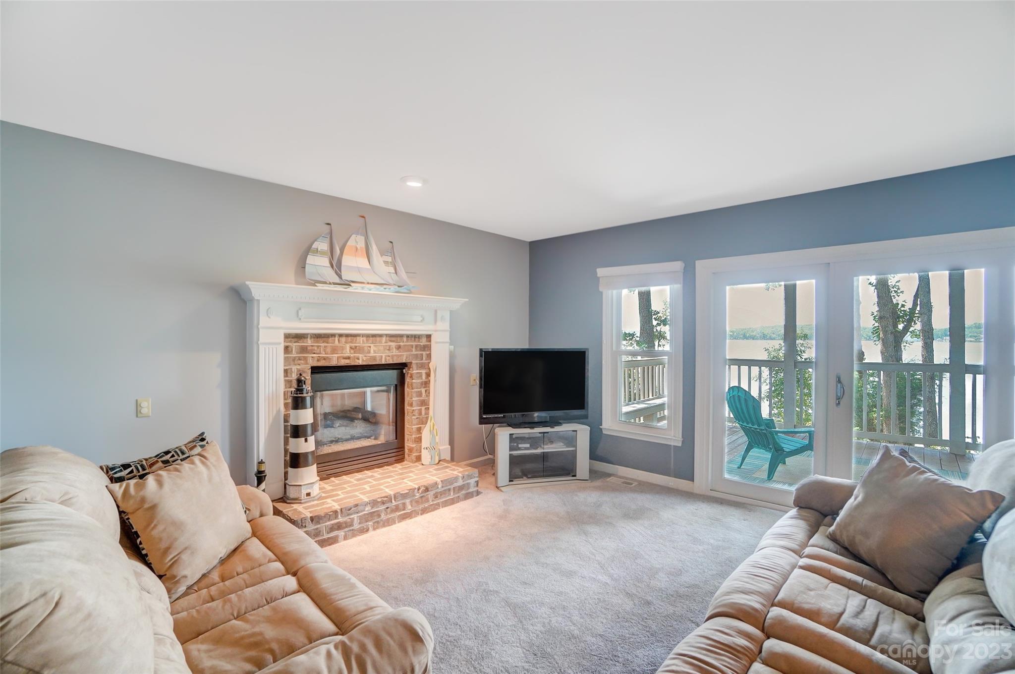 29025 Beaver Run Tega Cay, SC 29708 - Photo 29 of 42 a living room with furniture a fireplace and a flat tv screen next to a window