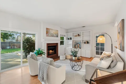 a living room with fireplace furniture and a floor to ceiling window