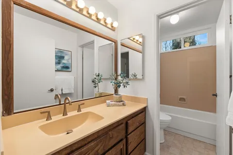 a bathroom with a sink double vanity granite tub and a mirror
