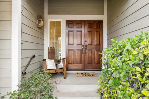 front view of a house with a potted plant and a window