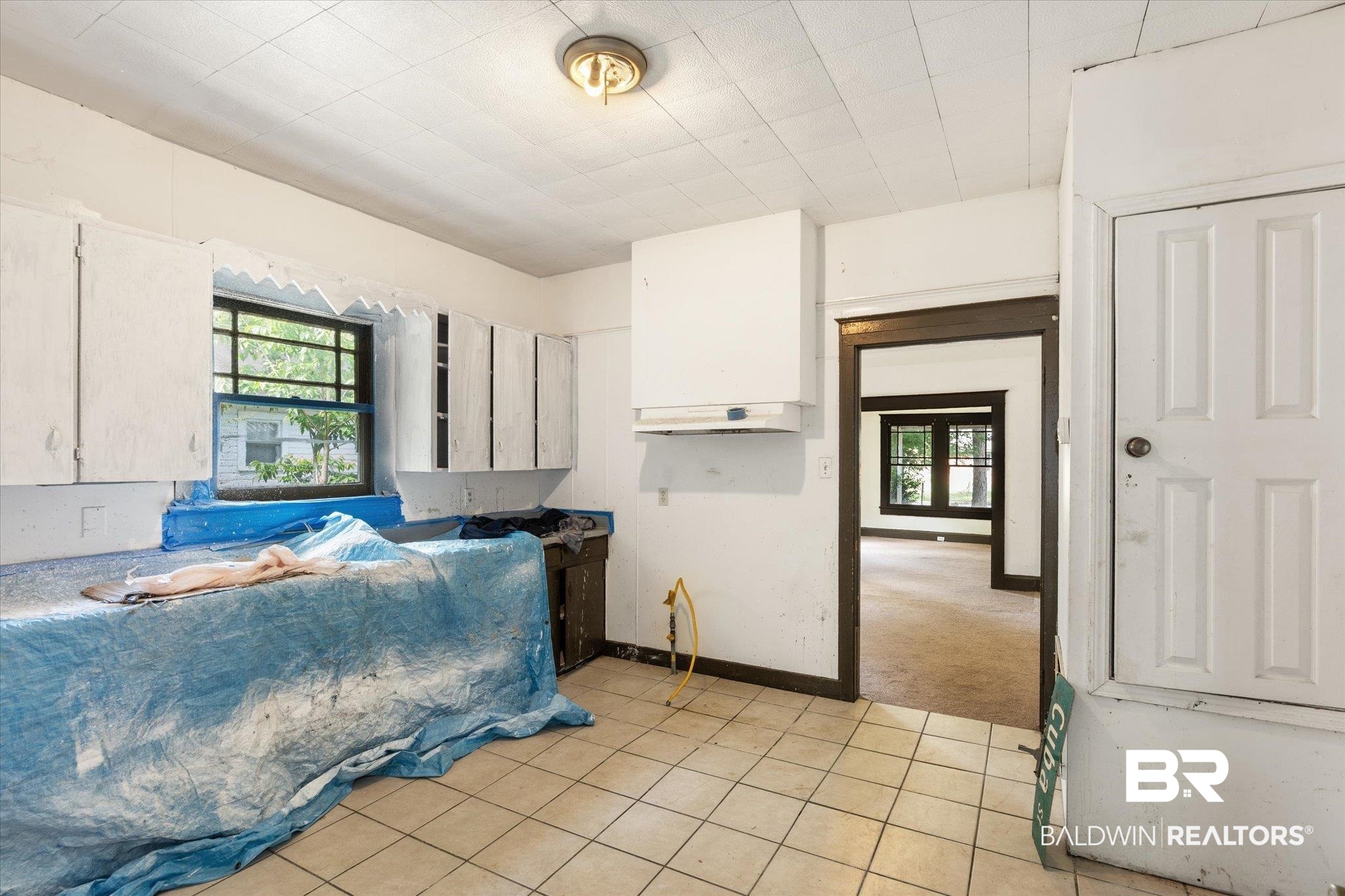 672 Burden Street Mobile, AL 36607 - Photo 7 of 20 Kitchen with healthy amount of natural light, white cabinets, and light tile patterned floors